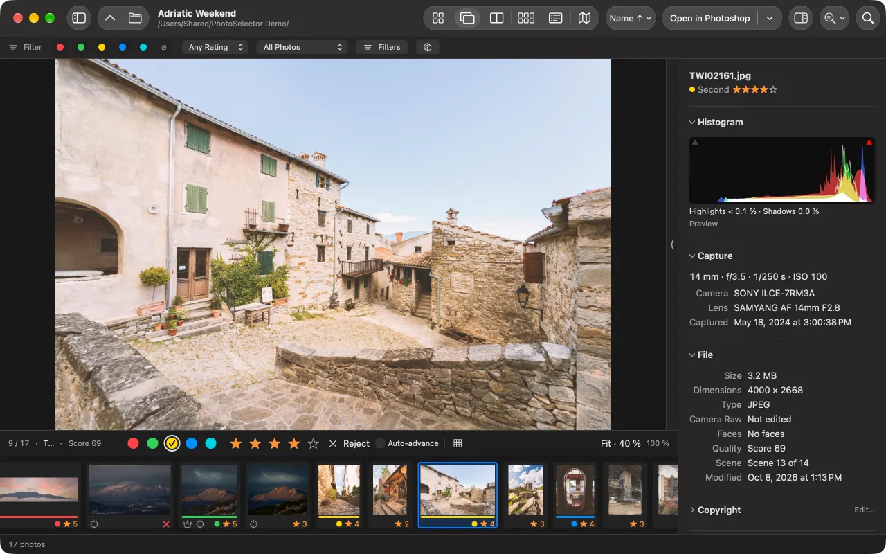 The Loupe: one large photo of a stone village square, a decision row with labels, stars and Reject, and a filmstrip below; the inspector shows the histogram, camera, lens and capture time